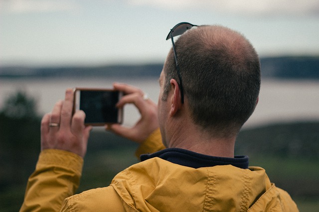 Mann fotografiert mit einem Smartphone